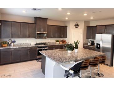 Modern kitchen with granite countertops and stainless steel appliances at 10766 Wild Parsley Ave, Las Vegas, NV 89129