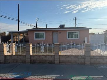 Pink single story house with white fence and paved driveway at 1972 H St, Las Vegas, NV 89106