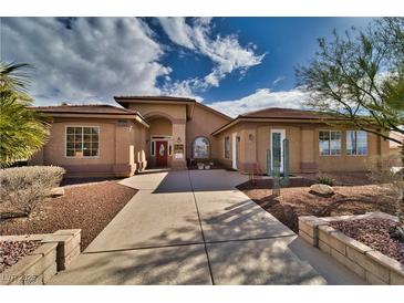 Single-story house with a terracotta roof, landscaped yard, and a paved walkway at 2221 E Winery Rd, Pahrump, NV 89048