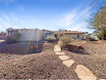 Single-story home with stone pathway, desert landscaping, and a spacious front yard at 311 E Desert Rose Dr, Henderson, NV 89015