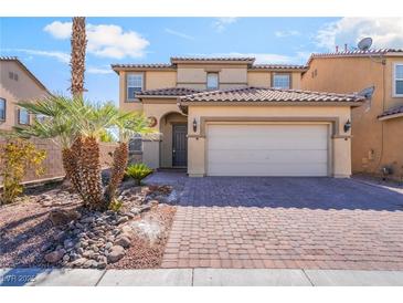 Two-story tan home with a tile roof, desert landscaping, and a brick driveway leading to a two-car garage at 3517 Colby Creek Ave, North Las Vegas, NV 89081