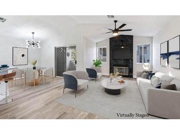 Virtually staged living room with modern decor and a fireplace at 601 Harvest Run Dr # 201, Las Vegas, NV 89145