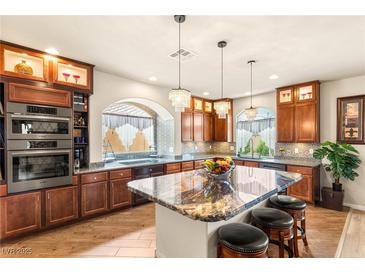 Bright kitchen featuring a large island, stainless steel appliances, and rich wood cabinetry at 6595 Creekside Cellars Ct, Las Vegas, NV 89139