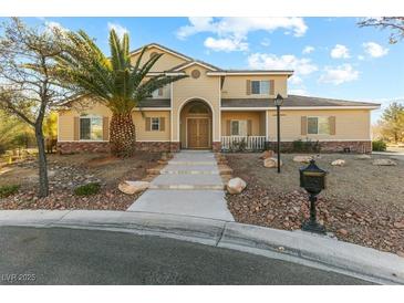Two-story house with tan siding, landscaping, and a palm tree in the front yard at 7611 Leybourne Ct, Las Vegas, NV 89131