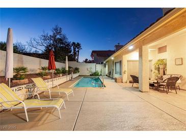 Inviting backyard with refreshing pool, lounge chairs, and covered patio perfect for relaxing at the end of the day at 9109 Lazy Hill Cir, Las Vegas, NV 89117