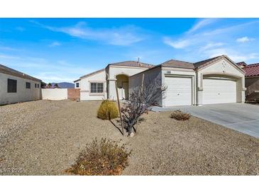 House exterior featuring a two-car garage and desert landscaping at 1006 Christopher View Ave, North Las Vegas, NV 89032