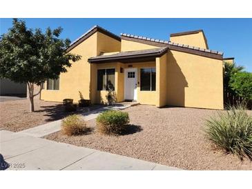 Tan two-story house with white door, landscaping, and gravel driveway at 1480 Hialeah Dr # B, Las Vegas, NV 89119