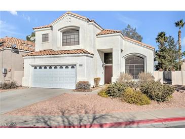 Two-story house with white exterior, a two-car garage, and landscaping at 1614 Redhawk Ct, Henderson, NV 89074