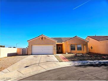 Tan one-story house with a two-car garage and desert landscaping at 3538 Canter Dr, North Las Vegas, NV 89032