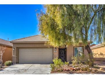 Beige house with a two-car garage and a large tree in the front yard at 4039 Welsh Pony St, Las Vegas, NV 89122