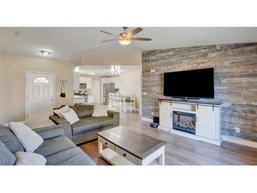 Spacious living room featuring a cozy fireplace and an accent wall at 451 Wright Way, Henderson, NV 89015