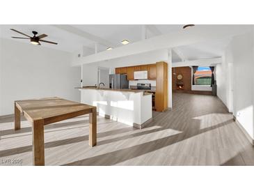 Open kitchen features wood cabinets, island, and stainless steel appliances at 6205 Hargrove Ave, Las Vegas, NV 89107