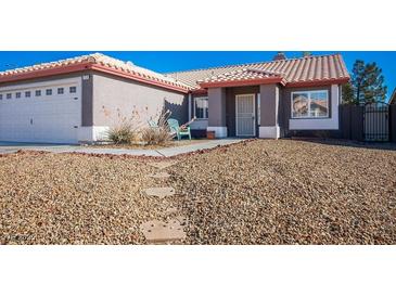 Single-story home with a well-manicured front yard and a gravel pathway at 7528 Pinto Bluff St, Las Vegas, NV 89131