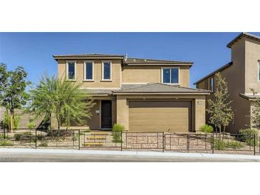 Two-story house with tan exterior, two-car garage, and landscaped front yard at 9280 Copernicus Ave, Las Vegas, NV 89143