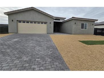 Modern single-story home with neutral exterior and paver driveway at 1770 Ironside St, Pahrump, NV 89048