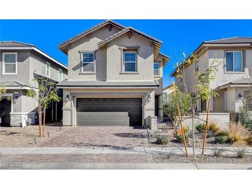 Two-story house with gray siding, dark garage door, and landscaped front yard at 710 Bamboo Bend Pl, Henderson, NV 89011