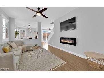 Bright living room with fireplace, hardwood floors, and comfortable seating at 2505 Cockatiel Dr, North Las Vegas, NV 89084