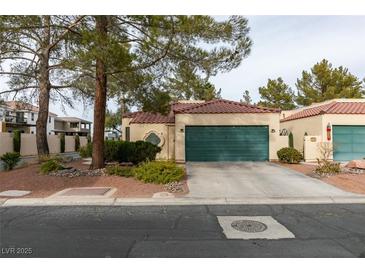 Single story home with green garage door and mature landscaping at 2714 Bridgepointe Dr, Las Vegas, NV 89121