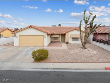 Single-story house with a beige exterior, tile roof, and a two-car garage at 350 Preston Dr, Henderson, NV 89015