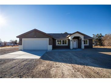 Newly constructed home with a two-car garage and neutral color scheme at 3880 Leonard St, Pahrump, NV 89060