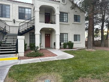 Two-story condo building with stairs, landscaping, and a walkway at 4707 Nara Vista Way # 104, Las Vegas, NV 89103