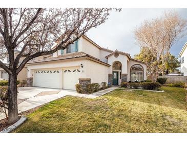 Two-story house with a three-car garage and landscaped lawn at 575 Dusty Palms Ln, Henderson, NV 89052