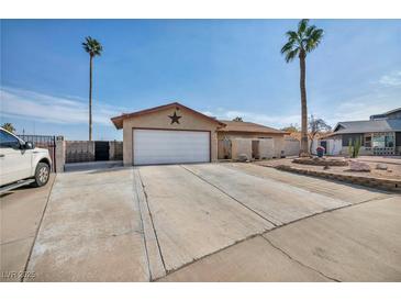 Single-story home with a spacious driveway and landscaped front yard at 659 Glenwood Ln, Henderson, NV 89002