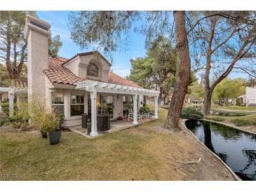 Relaxing patio with pergola, overlooking a peaceful canal at 6973 Emerald Springs Ln, Las Vegas, NV 89113