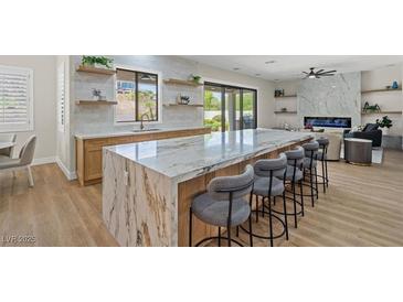 Modern kitchen with marble island, stainless steel appliances, and light oak cabinets at 7 Summit Walk Trl, Henderson, NV 89052