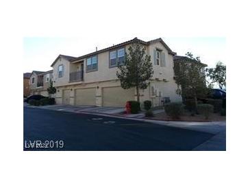 Tan two-story townhome with attached garage and driveway at , Las Vegas, NV 89118