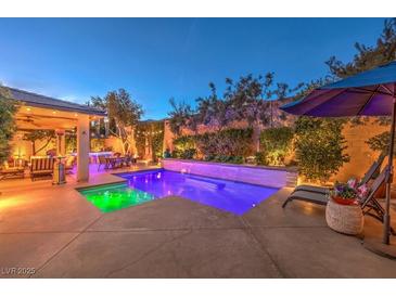 Luxury backyard oasis with a sparkling pool, patio furniture, and fire pit at 10414 Hemingway Ct, Las Vegas, NV 89149