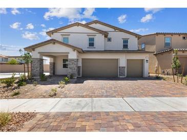 Two-story house with three-car garage, stone accents, and landscaped yard at 1070 Kelly Brook Ln, Henderson, NV 89011