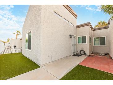 Exterior view of a light-colored stucco house with a small front yard and walkway at 2254 High Dunes Ln, Laughlin, NV 89029