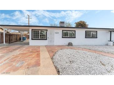 White single story home with landscaped yard and a covered patio at 2824 Bassler St, North Las Vegas, NV 89030