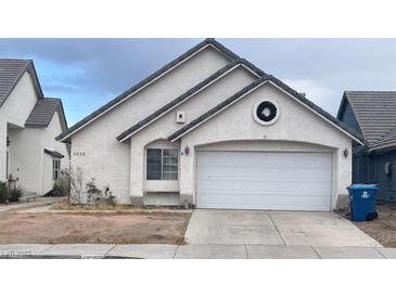 White stucco house with a two-car garage and landscaping at 3090 Spokane Dr, Las Vegas, NV 89121