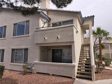 Tan stucco condo building with stairs and a balcony at 3425 E Russell Rd # 265, Las Vegas, NV 89120