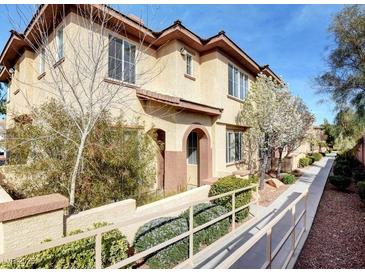 Tan two-story townhome with walkway and landscaping at 3820 Wiggins Bay St # 201, Las Vegas, NV 89129