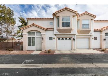 Two-story home with attached two-car garage and landscaping at 6860 Coral Rock Dr, Las Vegas, NV 89108