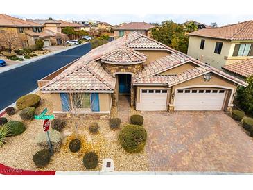 Single-story house with three-car garage, and landscaped yard at 7976 Sleeping Lily Dr, Las Vegas, NV 89178