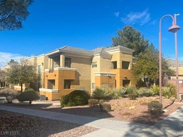 Tan-colored apartment building with well-maintained landscaping and ample outdoor lighting at 8070 W Russell Rd # 2068, Las Vegas, NV 89113