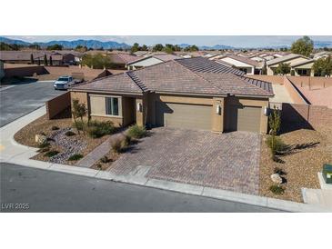 Single-story home with two-car garage, landscaped front yard, and brick driveway at 4430 Deliza Ln, Pahrump, NV 89061