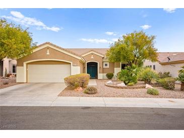 Single-story house with tan exterior, two-car garage, and landscaped front yard at 482 Bonnie Brook Pl, Henderson, NV 89012