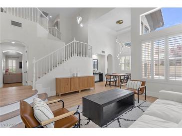 Bright living room with vaulted ceilings, hardwood floors, and a cozy fireplace at 10729 Grey Havens Ct, Las Vegas, NV 89135