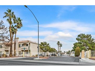 Low angle exterior shot of a multistory condo complex with a gated entrance and mature palm trees at 1900 N Torrey Pines Dr # 112, Las Vegas, NV 89108
