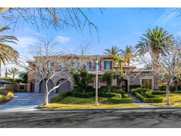 Beautiful two-story home featuring a stone facade, manicured lawn, and a three-car garage, set against a clear blue sky at 10117 Summit Canyon Dr, Las Vegas, NV 89144