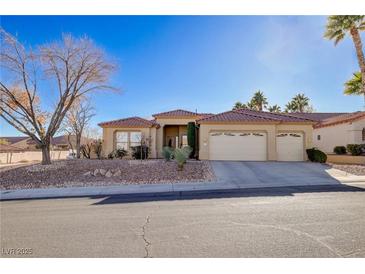 Single-story home with three-car garage, desert landscaping, and a tree in the front yard at 10201 Los Padres Pl, Las Vegas, NV 89134