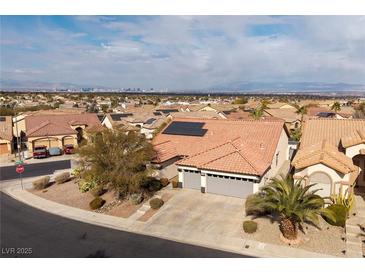 Aerial view of single-story house with solar panels, two-car garage, and desert landscaping at 1592 Bamboo Bay Dr, Henderson, NV 89012