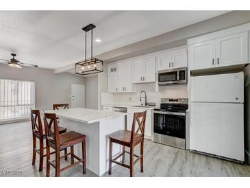 Modern kitchen with white cabinets, stainless steel appliances, and an island at 1906 Palora Ave, Las Vegas, NV 89169