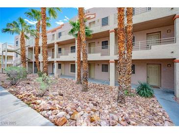 Two-story building with multiple units, desert landscaping, and palm trees at 2044 Mesquite Ln # 302, Laughlin, NV 89029