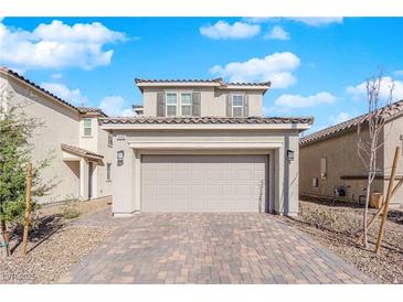 Two story home featuring a two car garage, stone driveway, neutral color, and low maintenance desert landscaping at 2430 Bellinzona Pl, Henderson, NV 89044